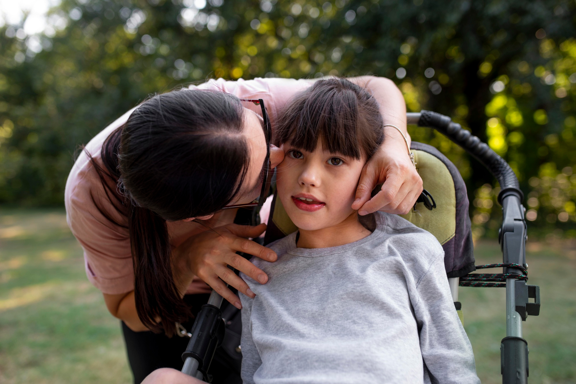 Disability Care Taker Playing With Child Girl in Wheelchair