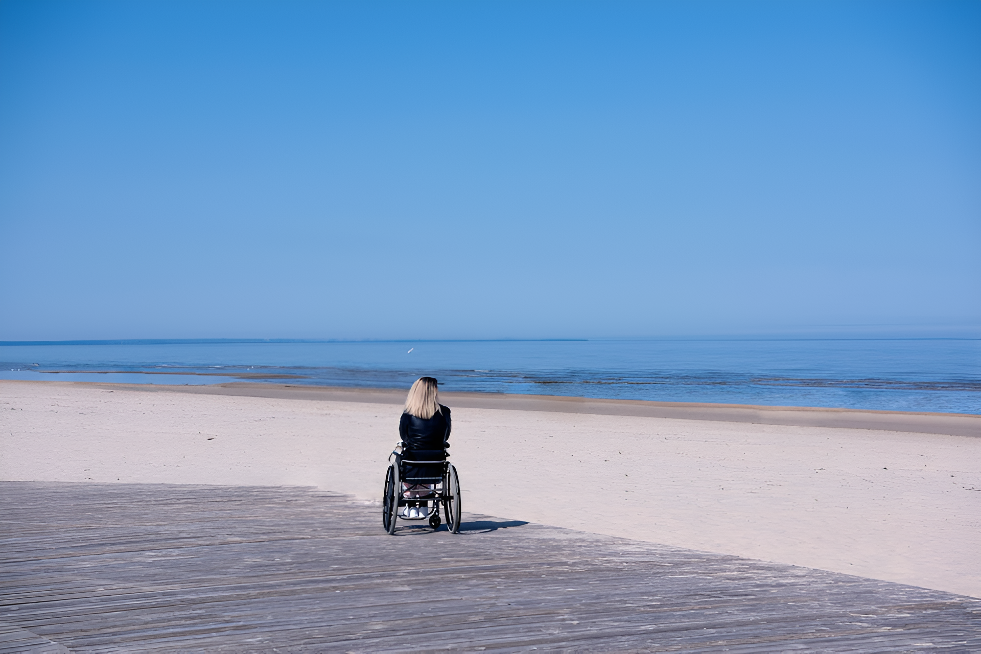 Lonely disabled young woman on Sunshine Coast ​beach_Sunny summer day_SafeLane Healthcare